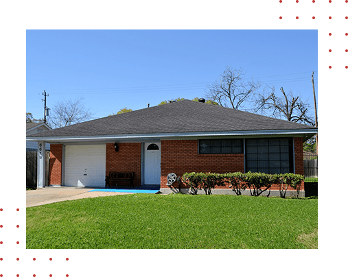 A brick house with green grass in front of it.