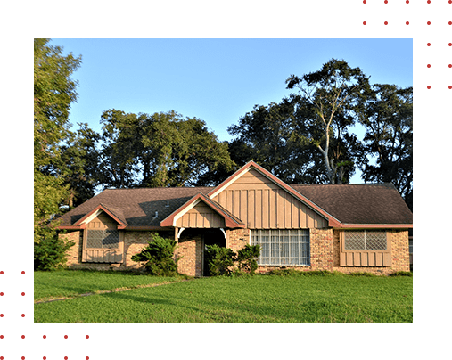 A brown house sitting in the middle of a green field.