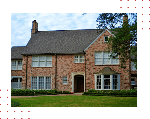 A brick house with green grass in front of it.